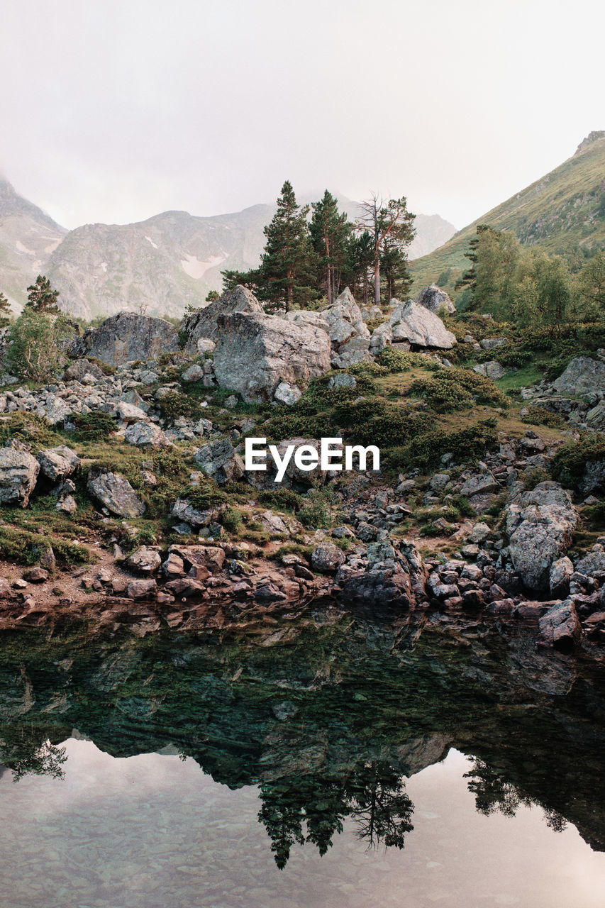 Scenic view of lake by mountain against sky