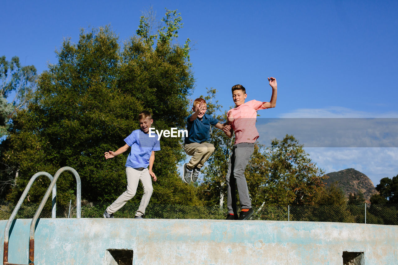 Brothers jump in the air in the direct sunlight