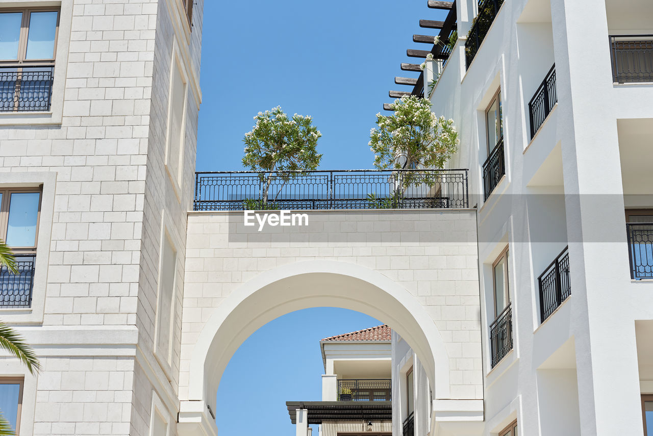 Arch with aleander flowers between buildings in a european city