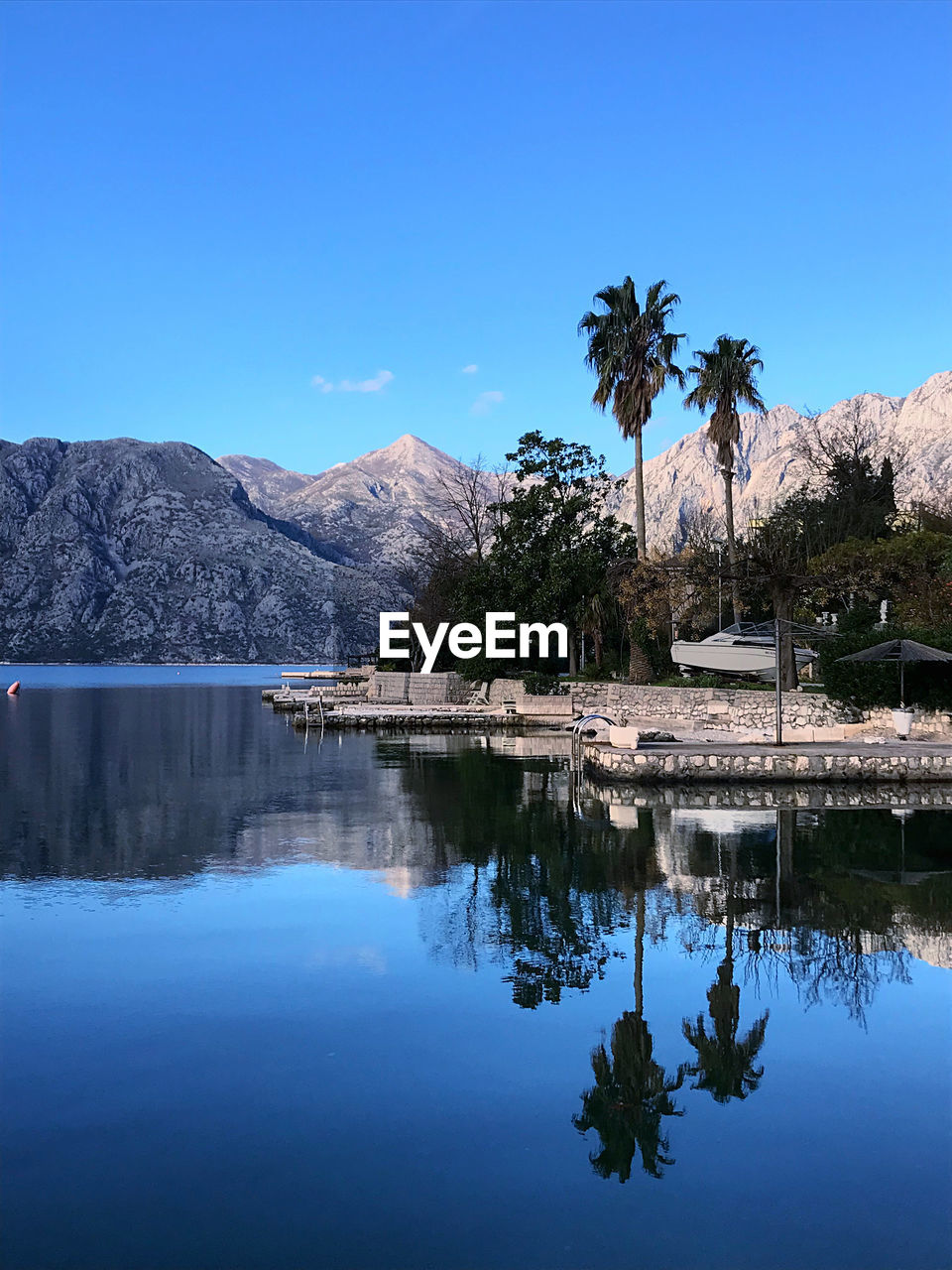 Scenic view of lake against clear blue sky