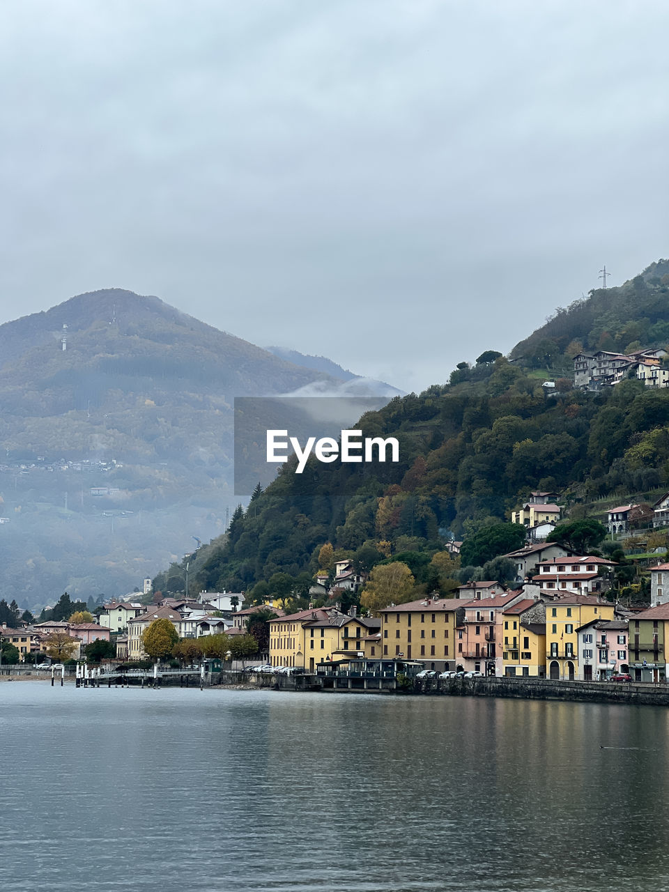 buildings by sea against mountain range