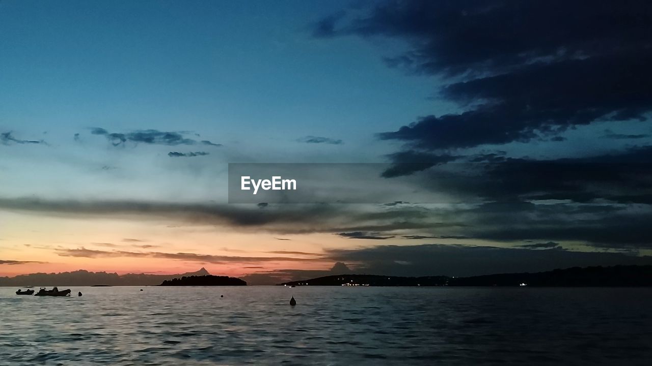 SCENIC VIEW OF SEA AT SUNSET