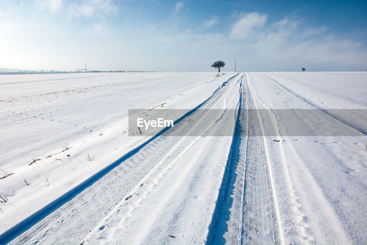 Tire tracks on snow covered road, winter view, eastern poland