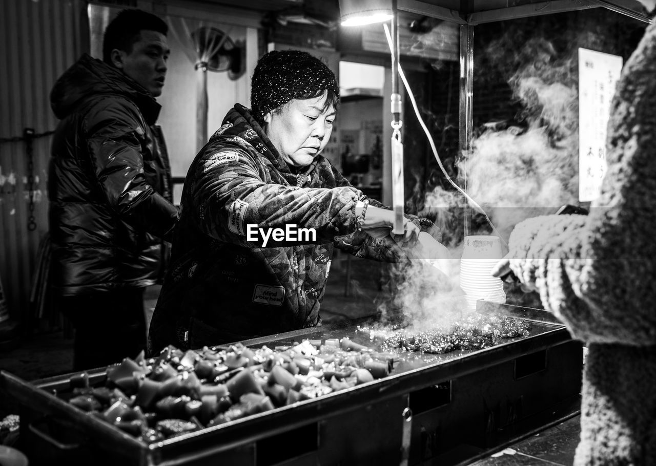 Woman selling meat at market stall