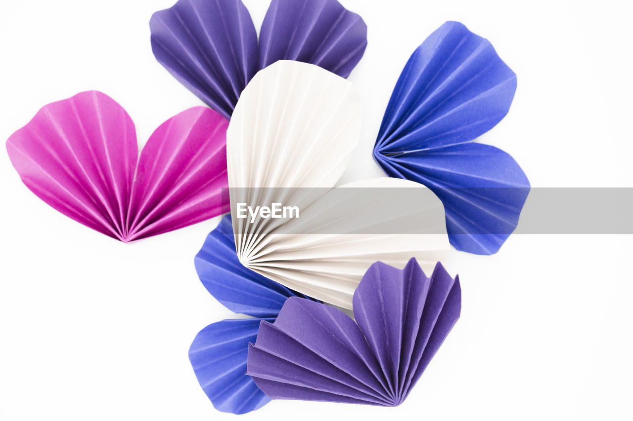 Origami hearts of various colors against white background