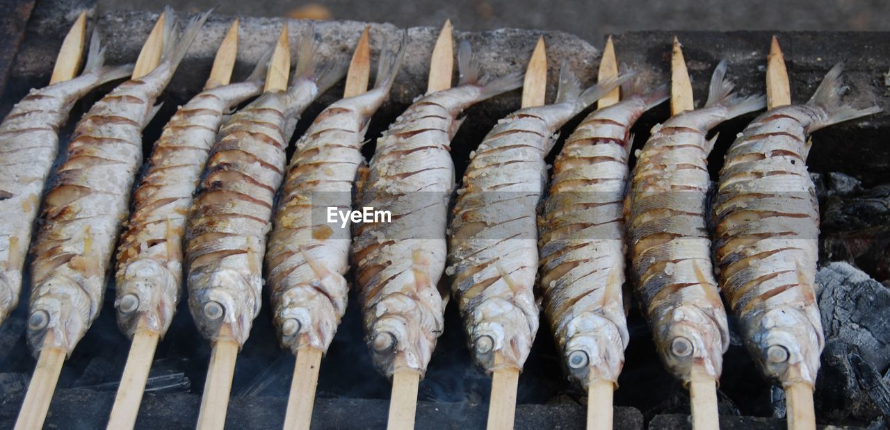 Fish being grilled over coal fire