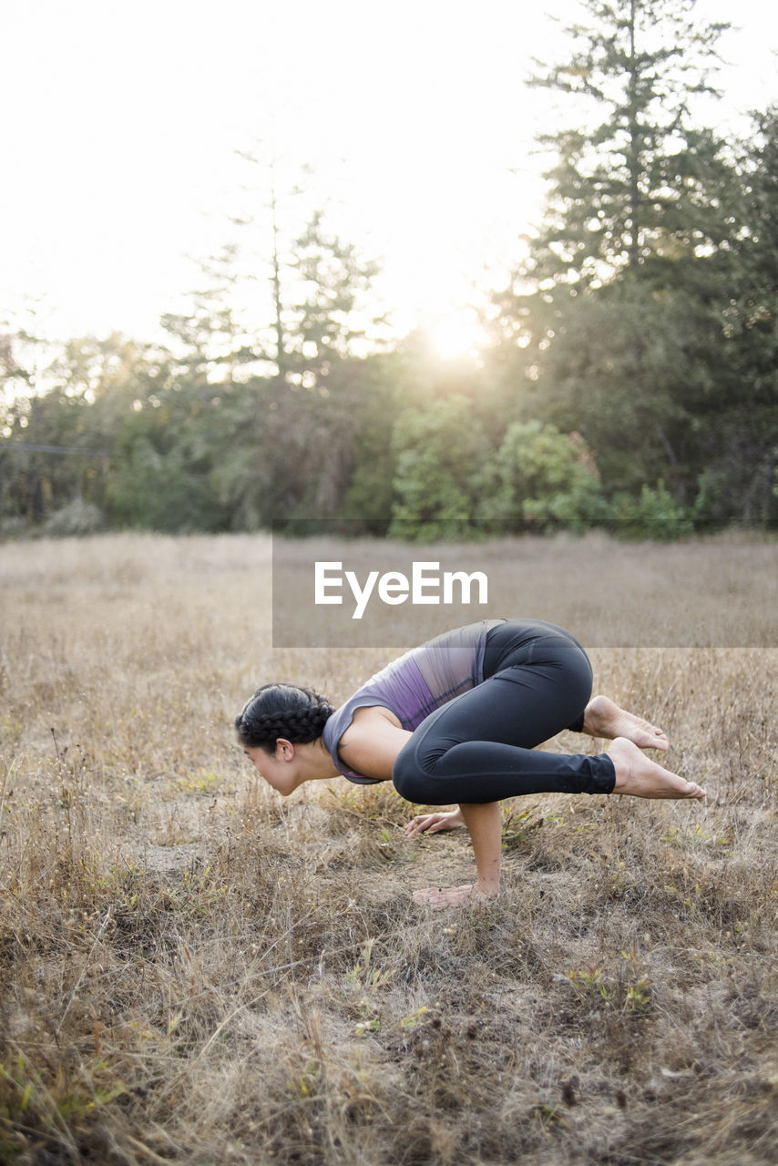 High angle view of woman practicing yoga posture at field