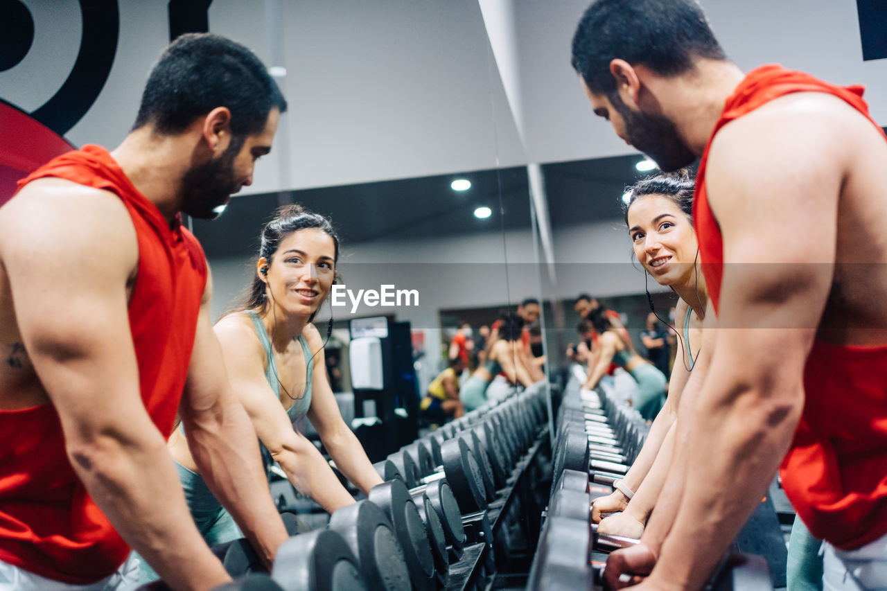 Side view of friends exercising at gym