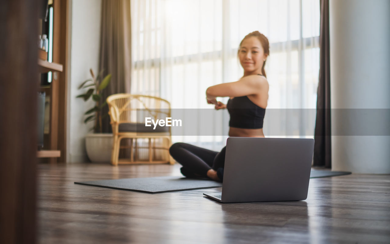 Woman learning exercise through laptop at home