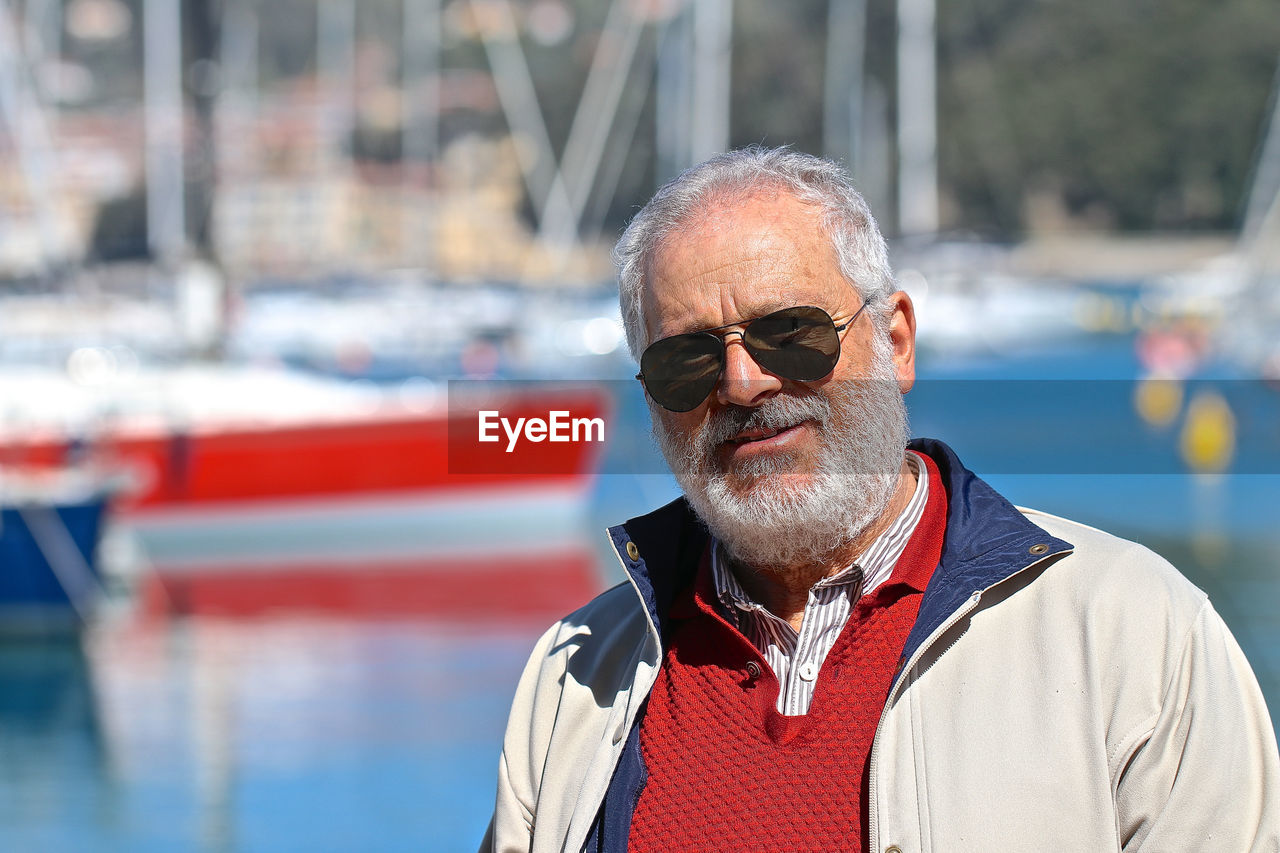 Portrait of man wearing sunglasses by sea