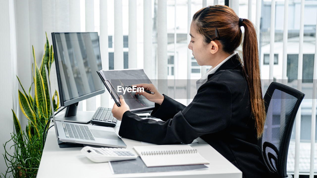 businesswoman using laptop at desk in office