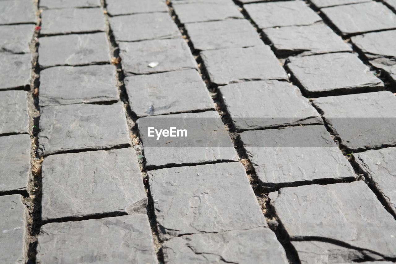 HIGH ANGLE VIEW OF COBBLESTONE FOOTPATH