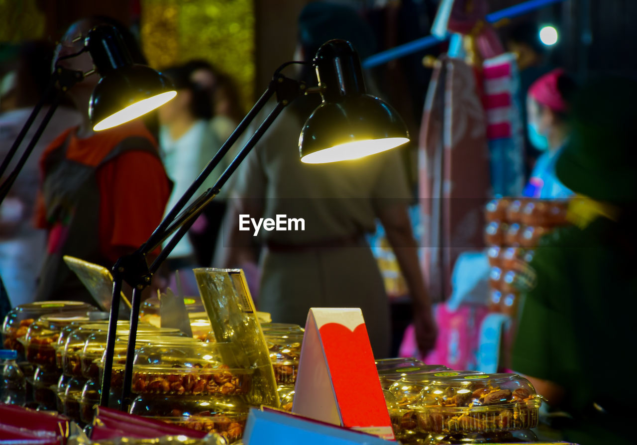 CLOSE-UP OF ILLUMINATED LANTERNS ON TABLE