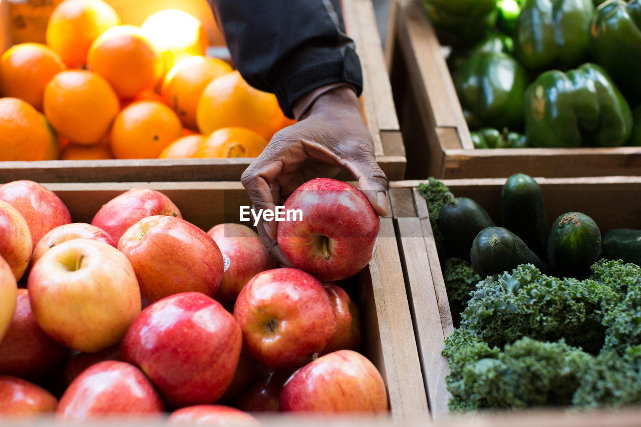 Cropped image of hand holding apple at market stall