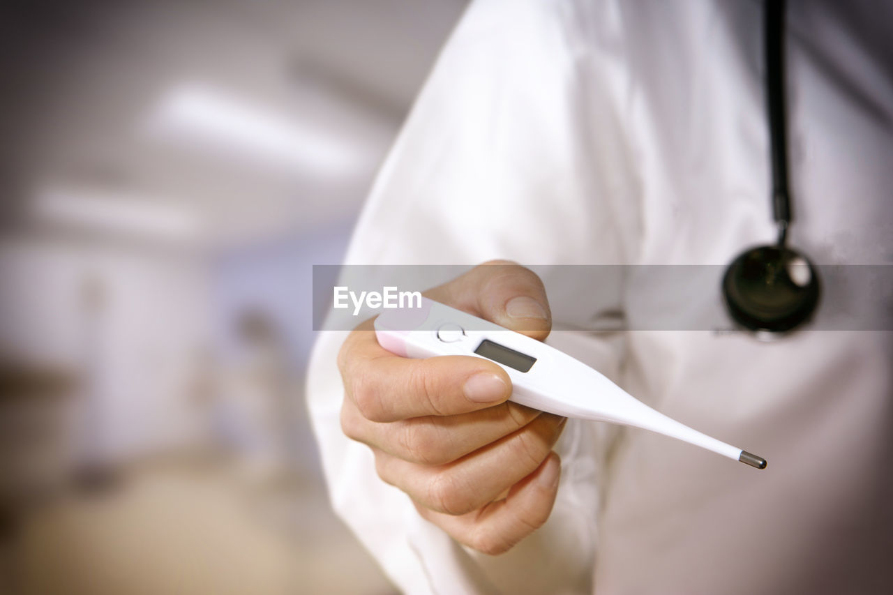 Close-up of doctor holding thermometer