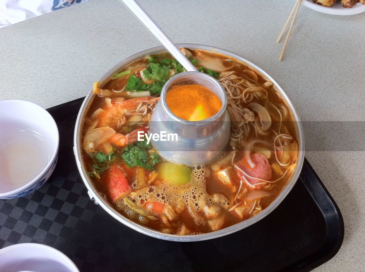 HIGH ANGLE VIEW OF SOUP IN GLASS ON TABLE