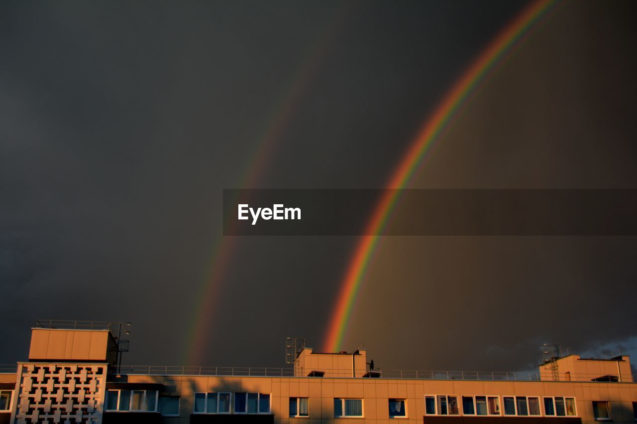 RAINBOW OVER BUILDINGS IN CITY AGAINST SKY