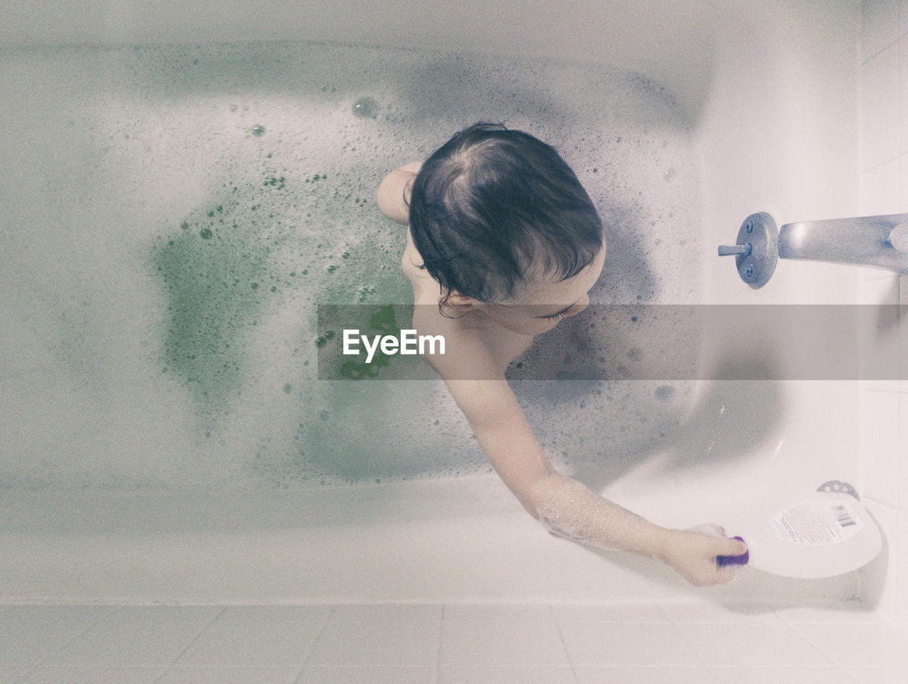 High angle view of girl in bathtub at home