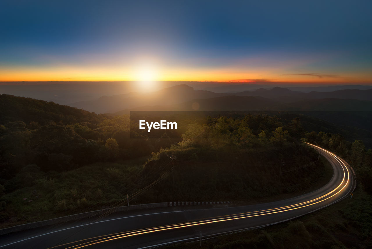 Road and mountains against sky during sunset