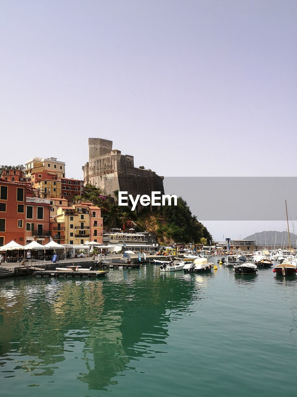 Buildings by seaside against clear sky