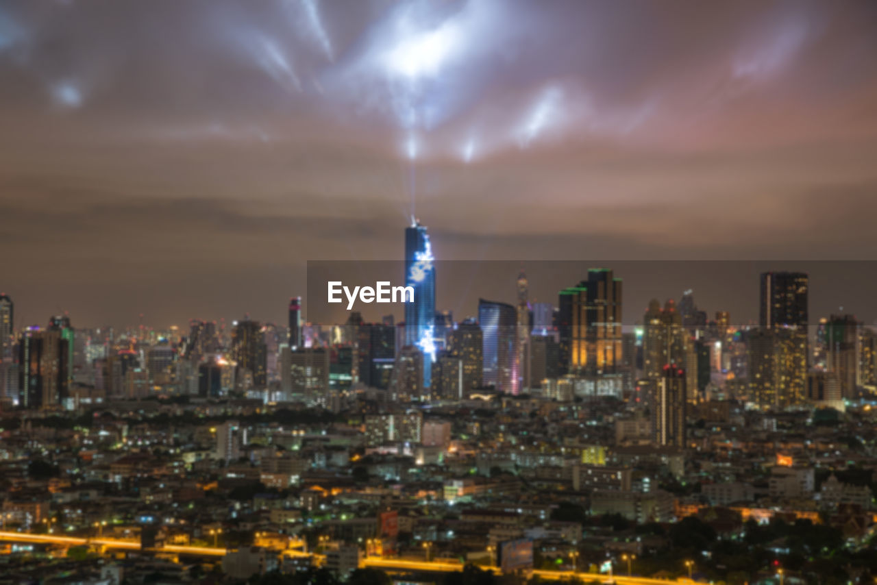 ILLUMINATED BUILDINGS IN CITY AGAINST SKY