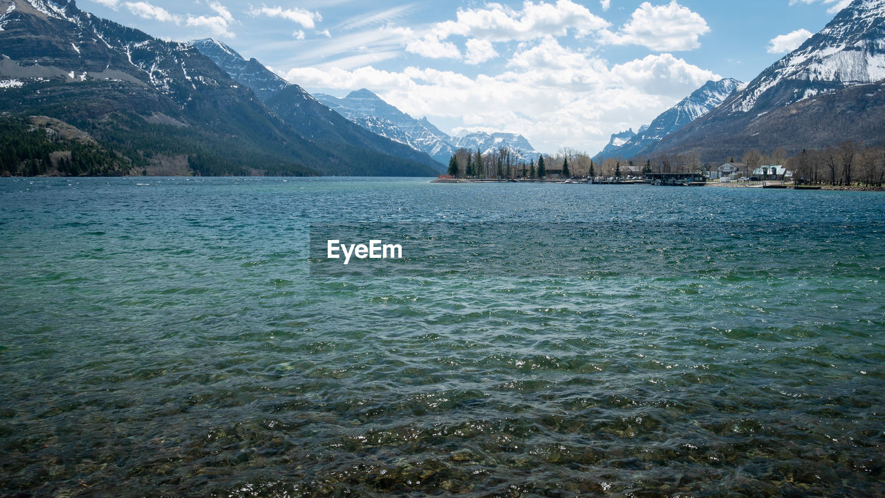 Small town on the bank of lake surrounded by mountains, shot in waterton national park, alberta