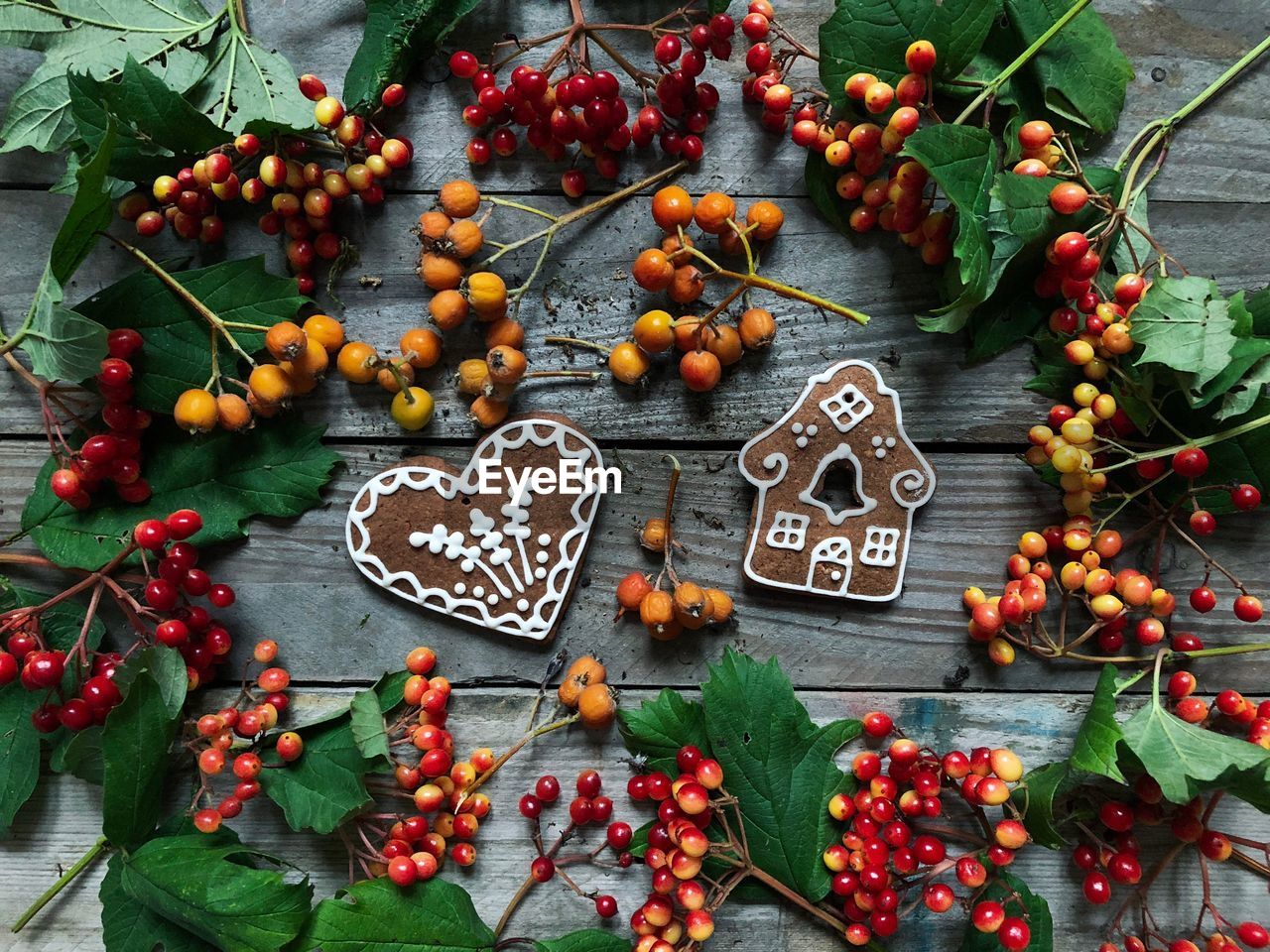 Directly above shot of gingerbread cookies and berries on wooden table