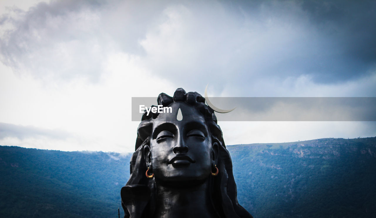 Low angle view of shiva statue against sky