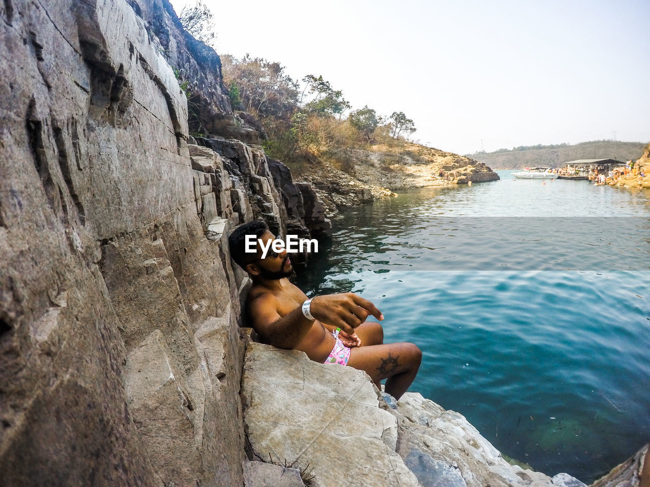 YOUNG MAN SITTING ON ROCK