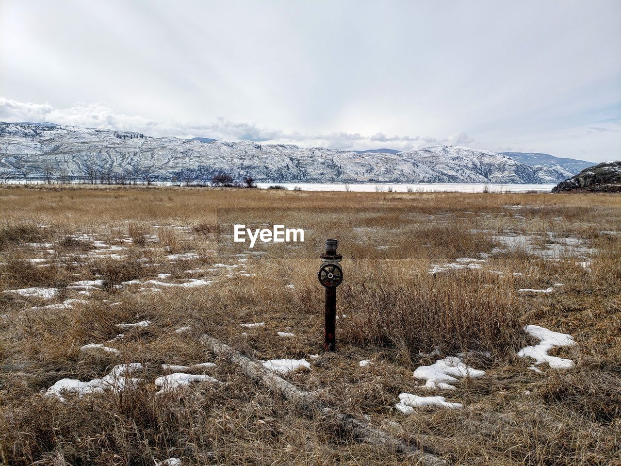 Scenic view of snow covered field against sky