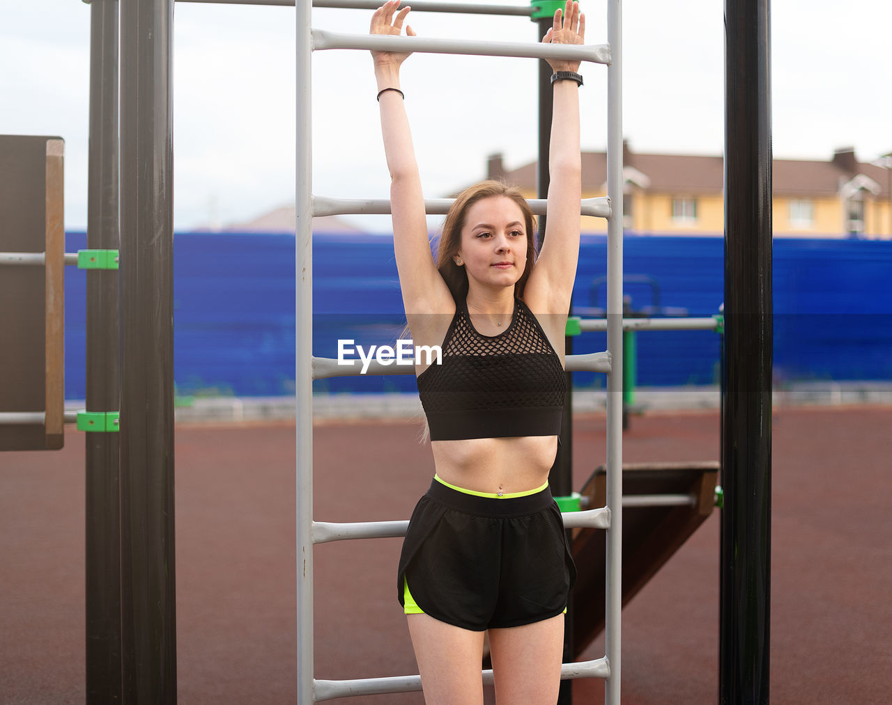 Young woman exercising by ladder