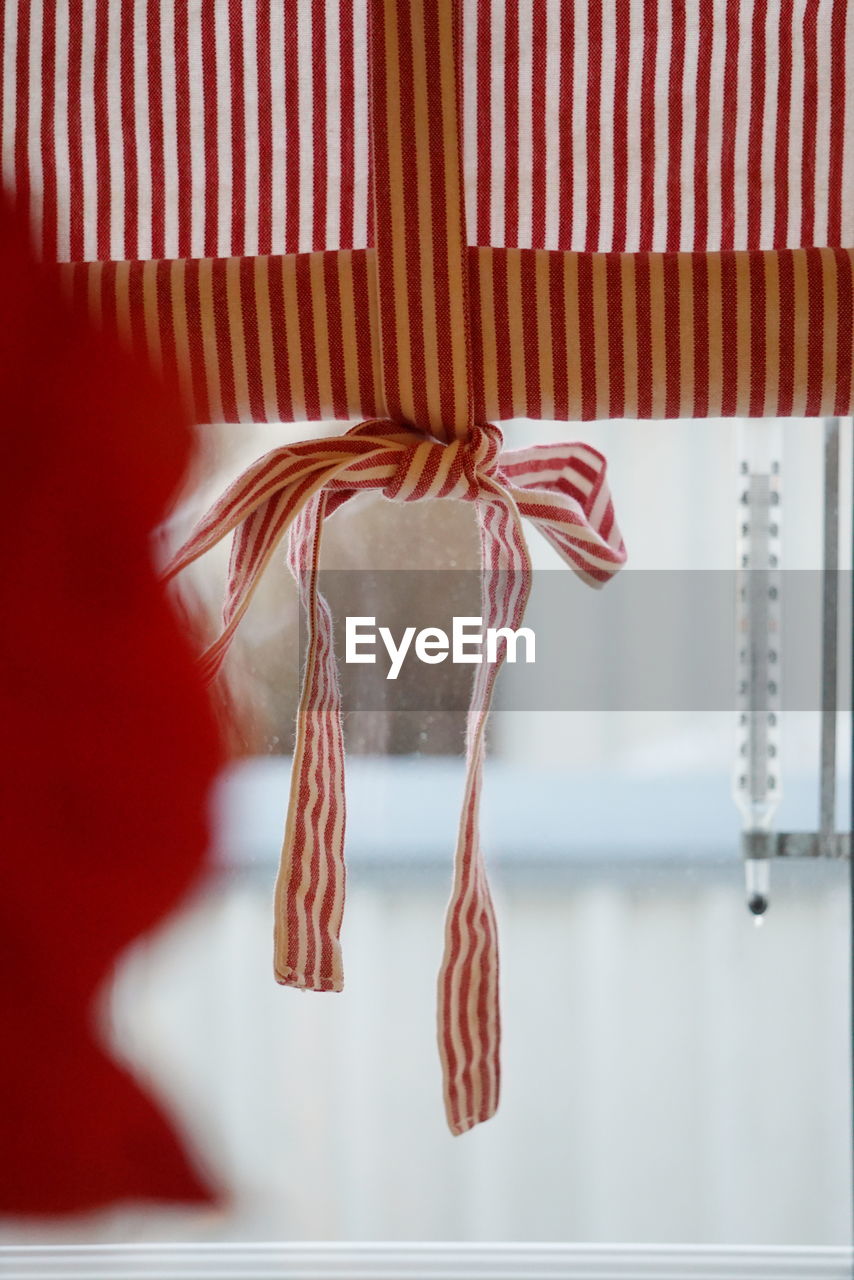 Striped window curtain hanging at home