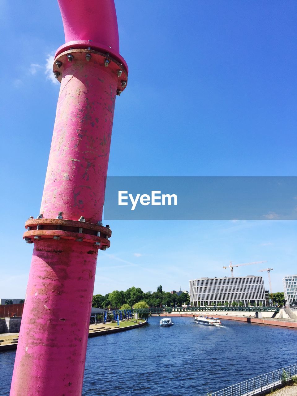 River by building in city against blue sky