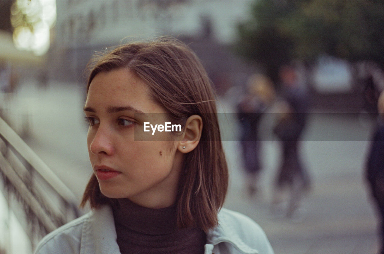 Portrait of young woman looking away outdoors