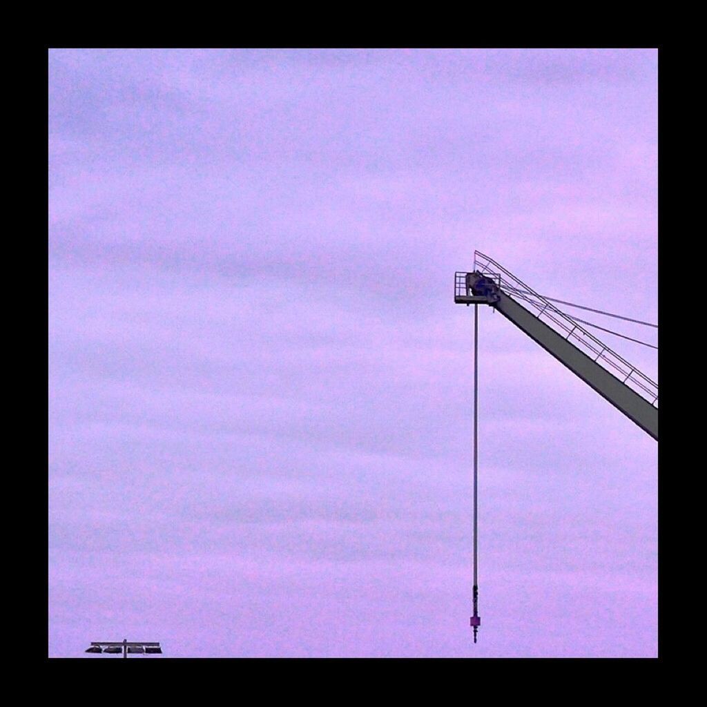 Low angle view of crane against sky