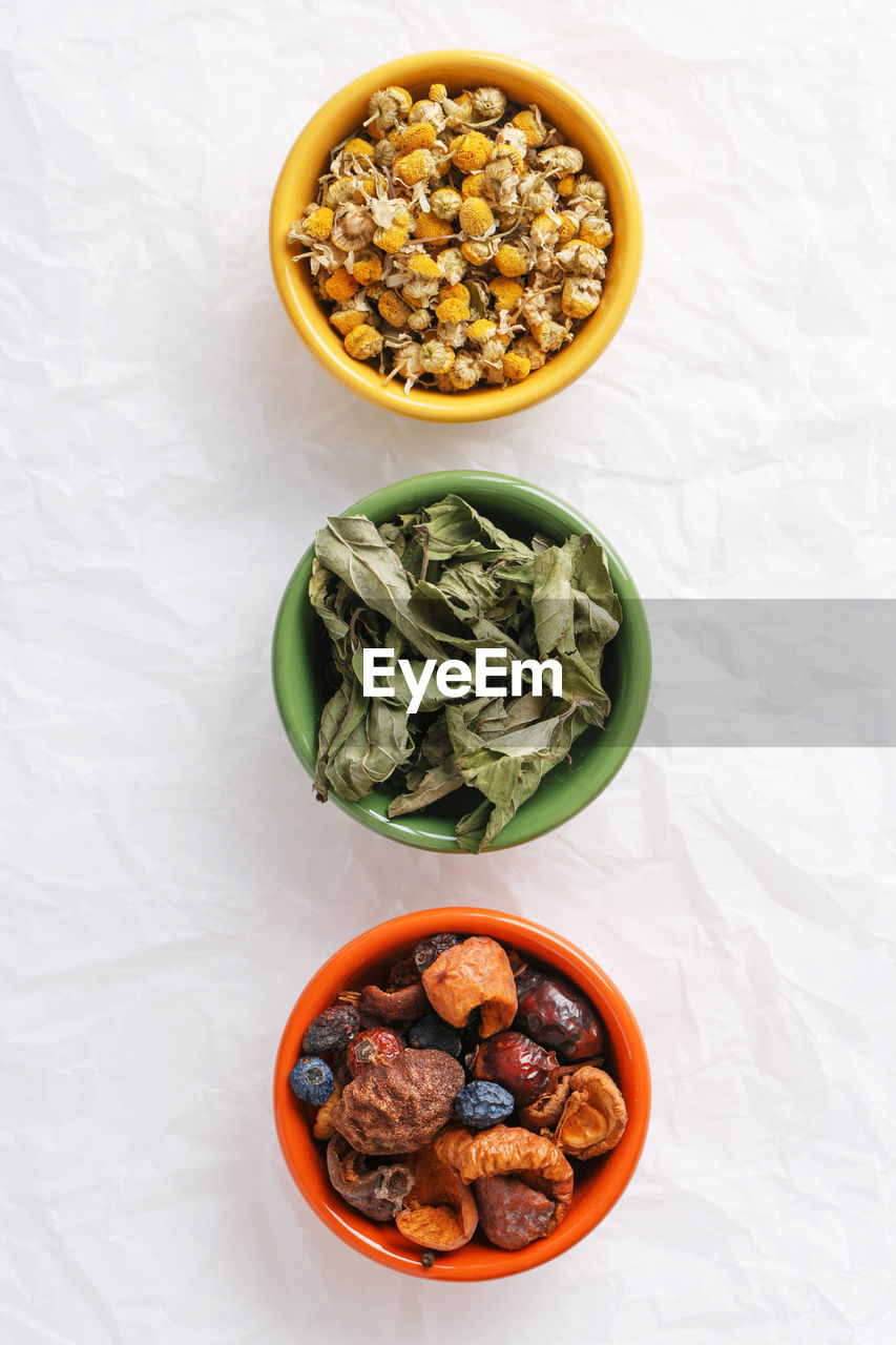 High angle view of ingredients in bowls on white paper