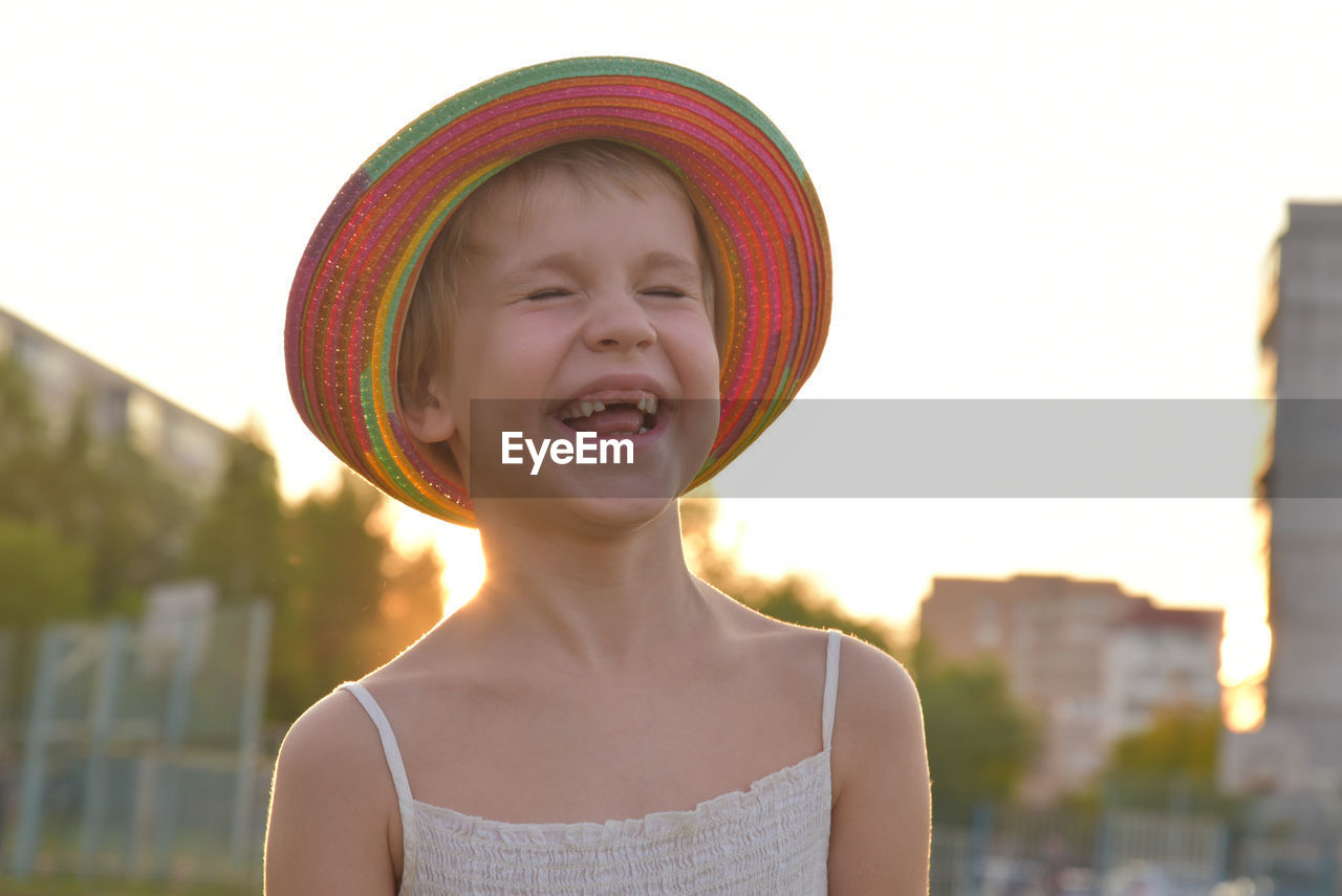 PORTRAIT OF SMILING BOY WEARING HAT AGAINST WALL