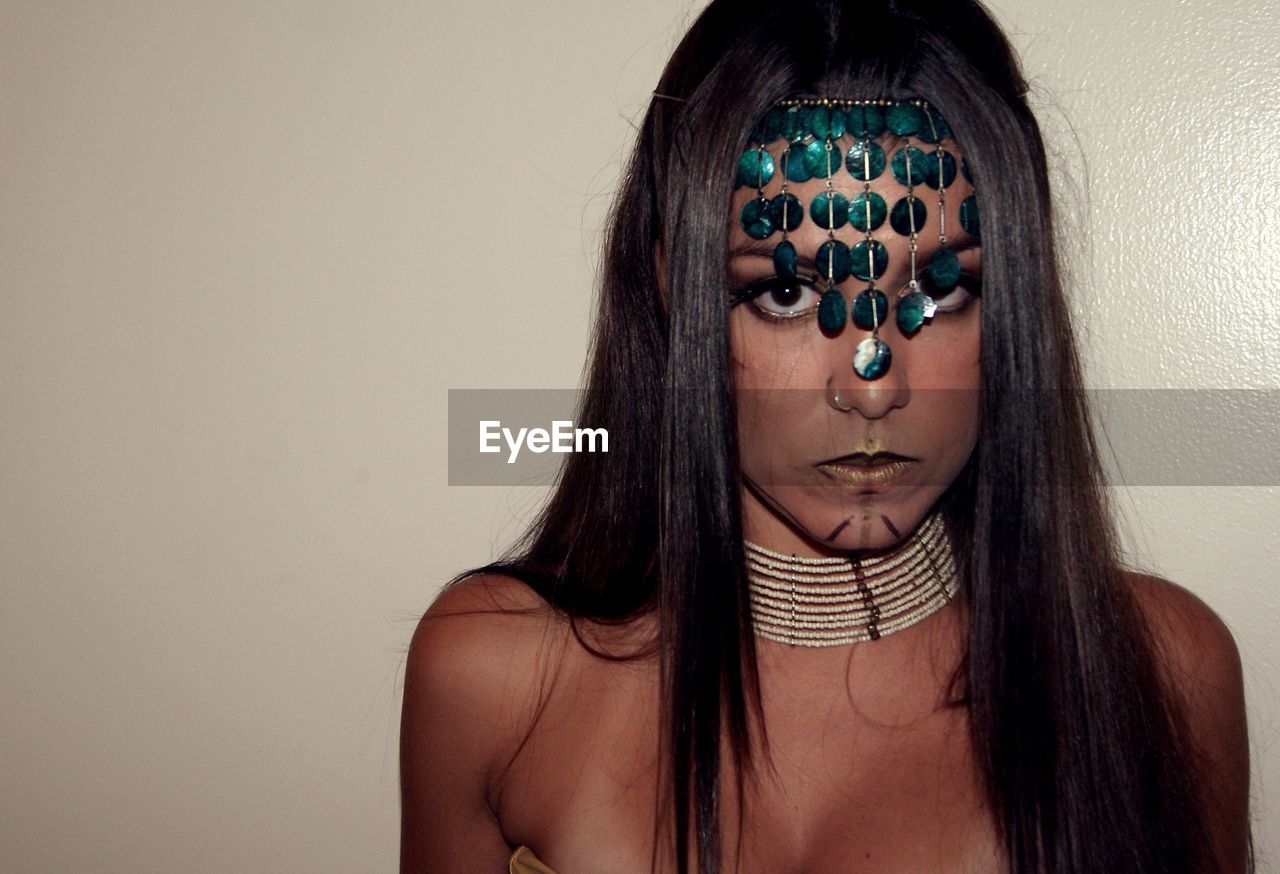 Close-up portrait of woman in tribal costume during halloween by wall