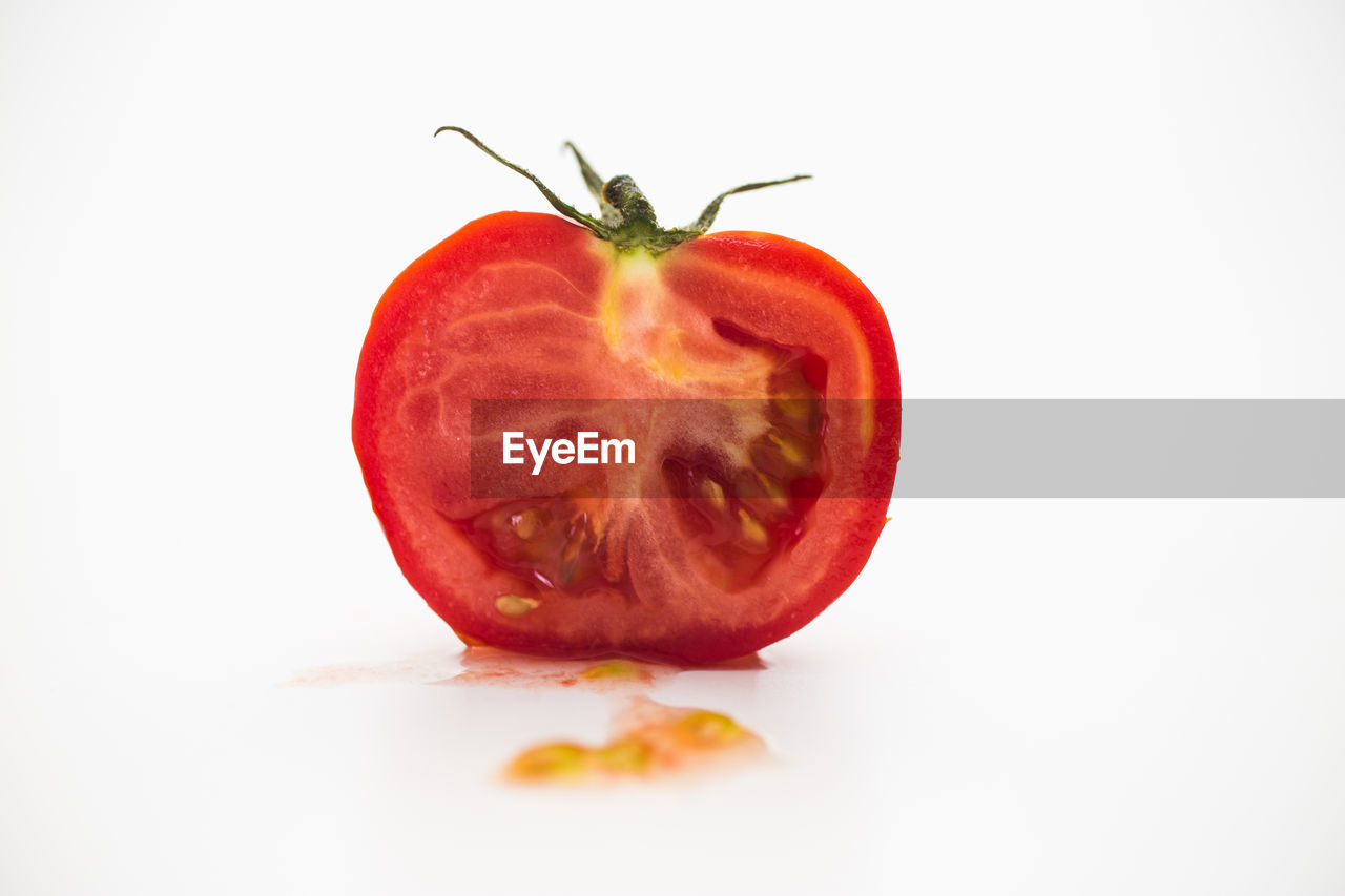 Close-up of slice of tomato against white background