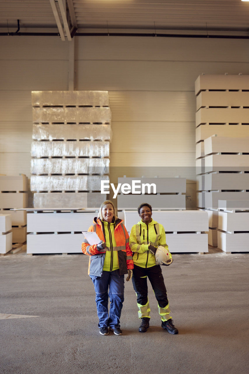 Portrait of smiling multiracial female coworkers standing in distribution warehouse