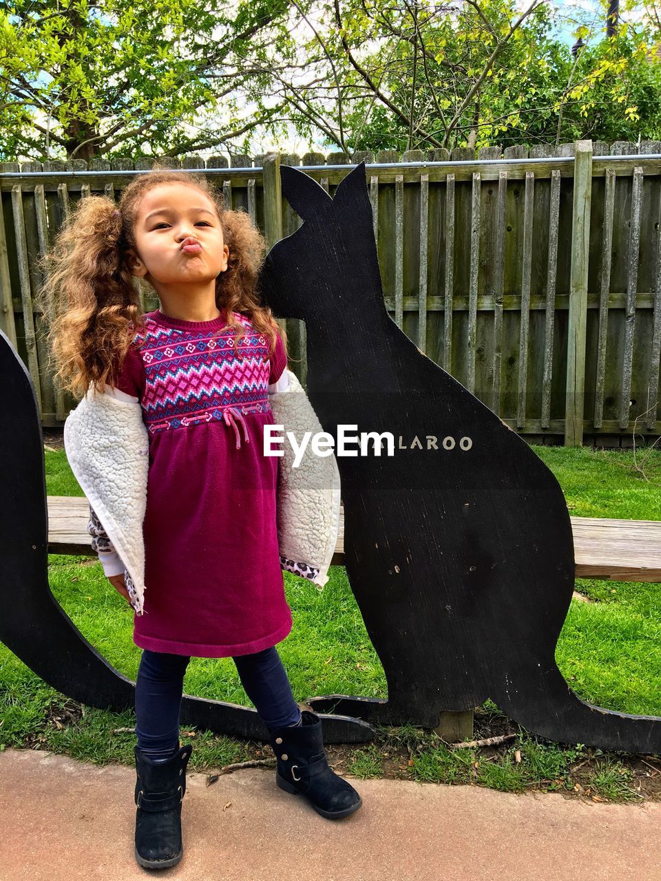 FULL LENGTH OF GIRL STANDING AGAINST TREES