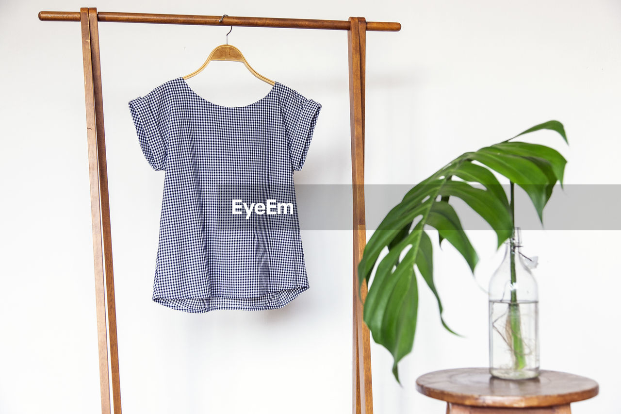 Woman blouse with blue blouse cotton on wooden hangers.