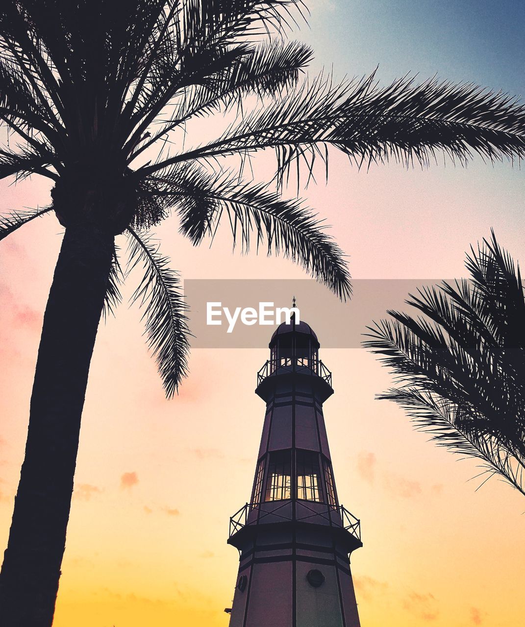 Low angle view of silhouette tower against sky during sunset