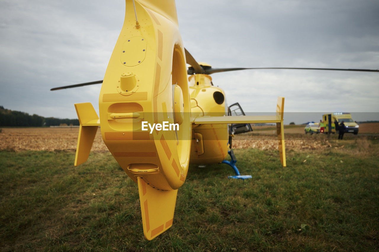 Helicopter of emergency medical service landing on field next to road. 