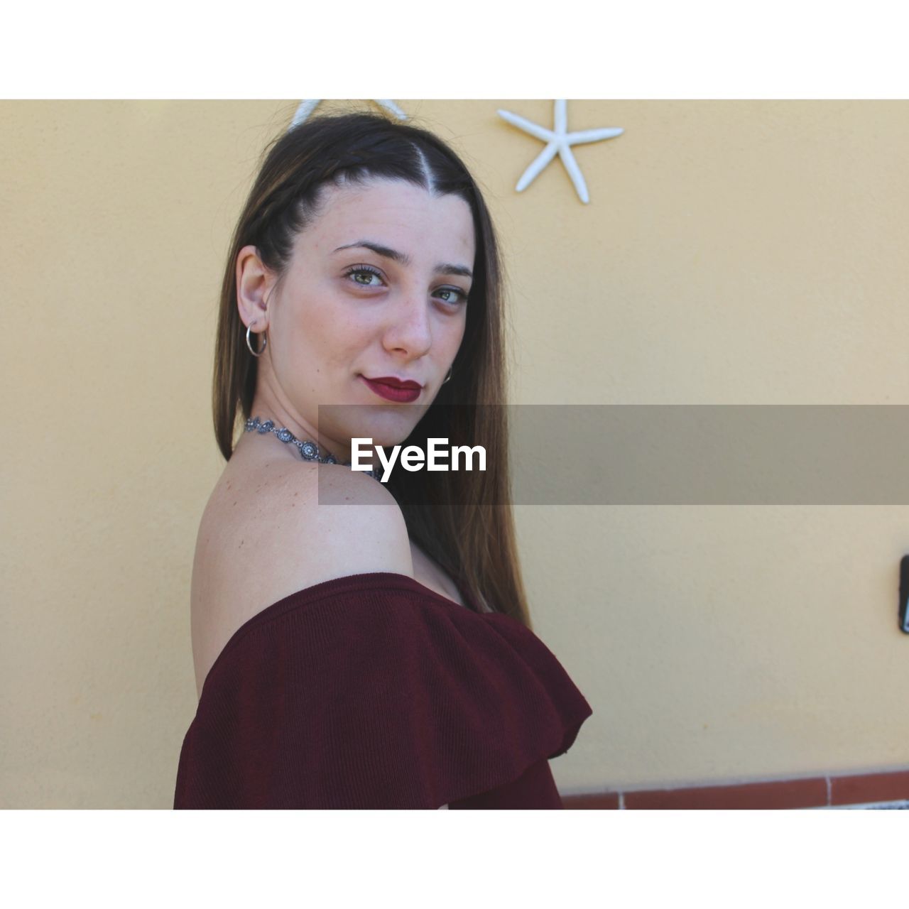 Portrait of young woman against wall