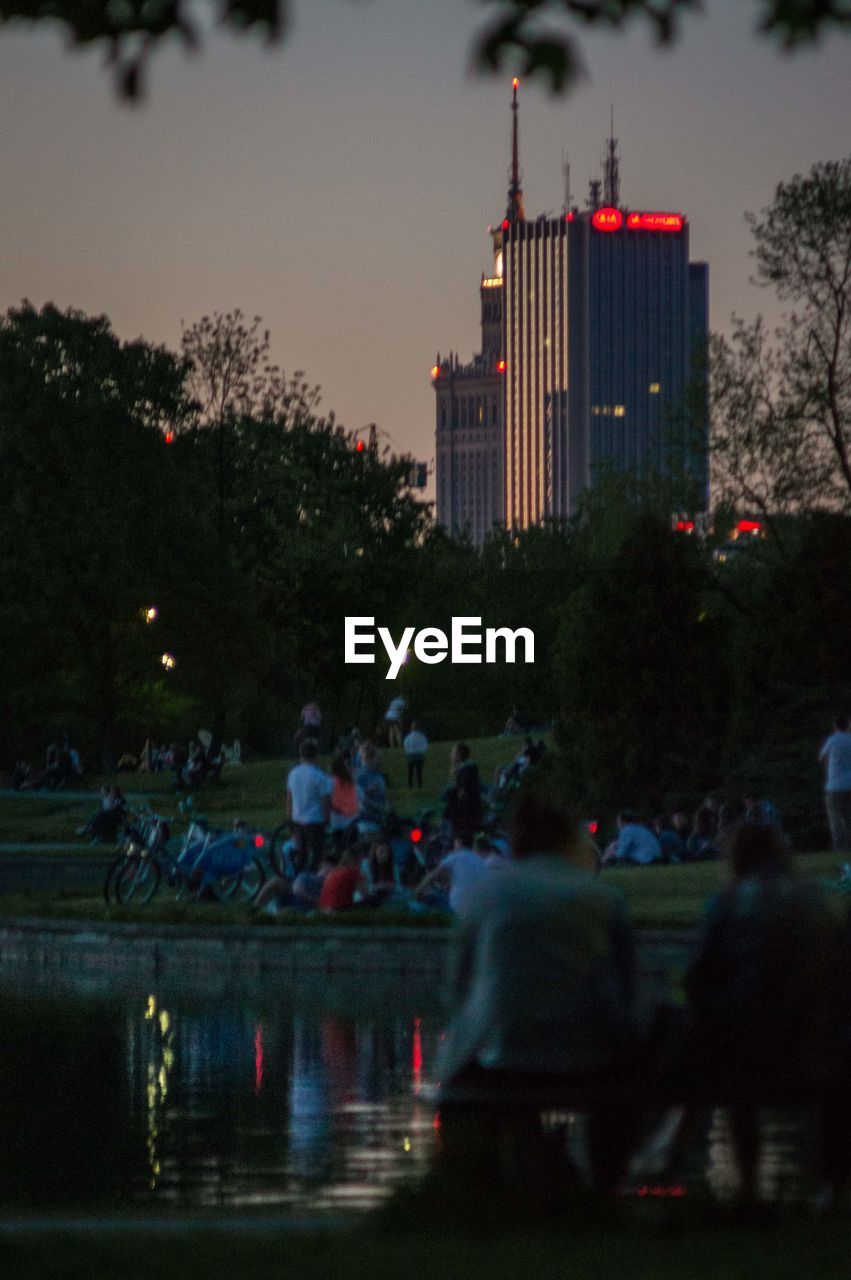 PEOPLE IN ILLUMINATED CITY AT NIGHT