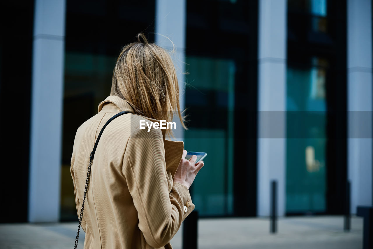 Caucasian woman using smartphine at city street