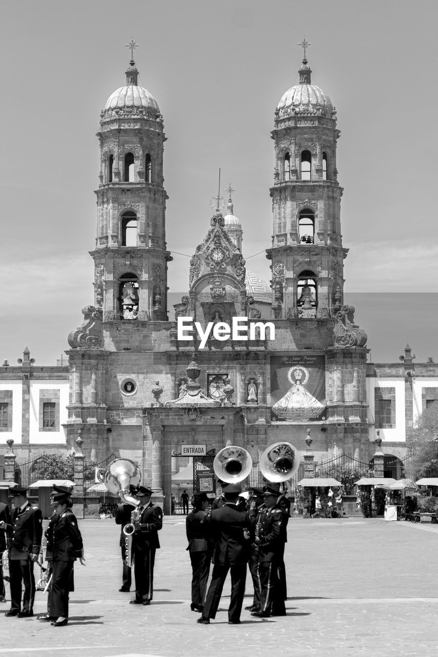 People in front of cathedral with musical instruments