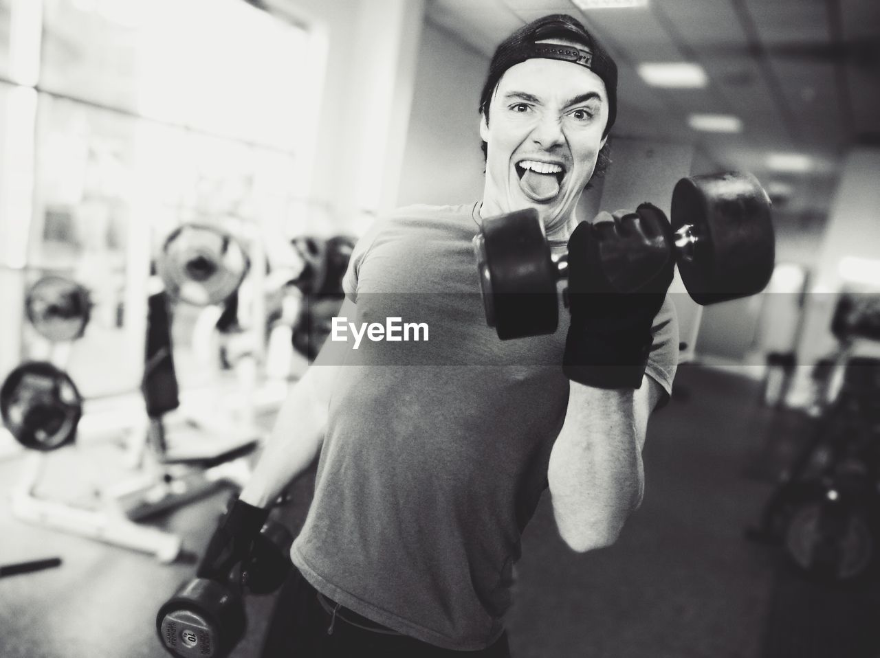 Portrait of man lifting dumbbells in gym