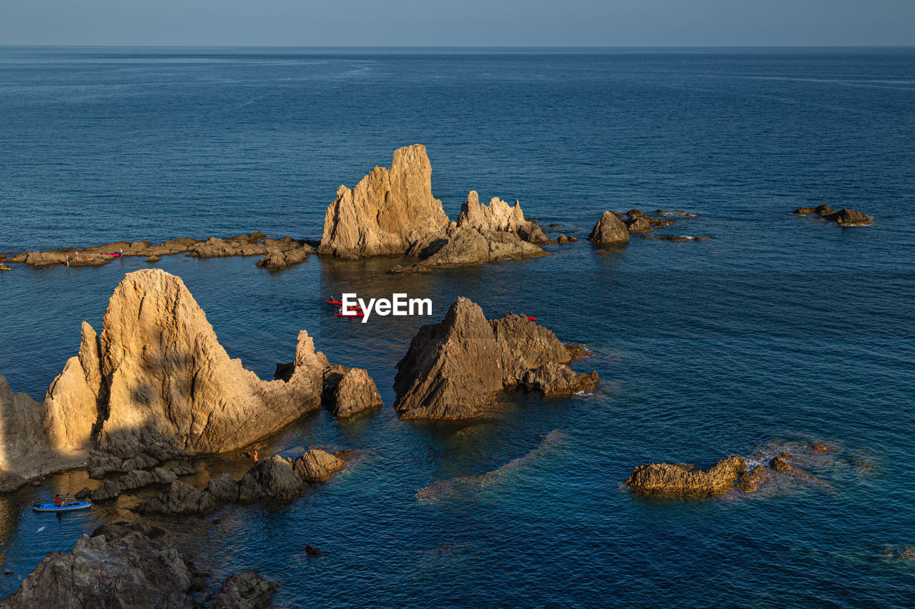 ROCKS IN SEA AGAINST SKY